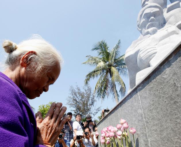 Survivor Pham Thi Thuan prays during the memorial on Friday. Photo: Reuters 