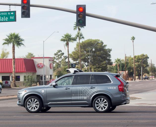 A self-driving Volvo vehicle, purchased by Uber, moves through an intersection in Scottsdale,...