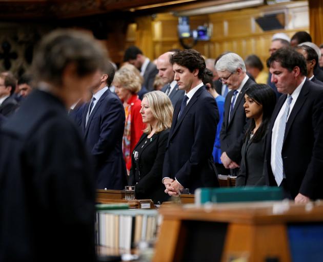 Prime Minister Justin Trudeau (centre) joins fellow MPs in a moment of silence in the House of...