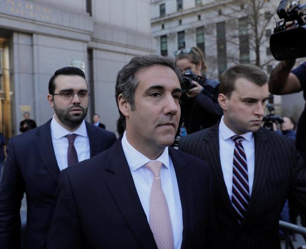 The FBI raided Michael Cohen's (centre) office and home on April 9, infuriating President Donald...