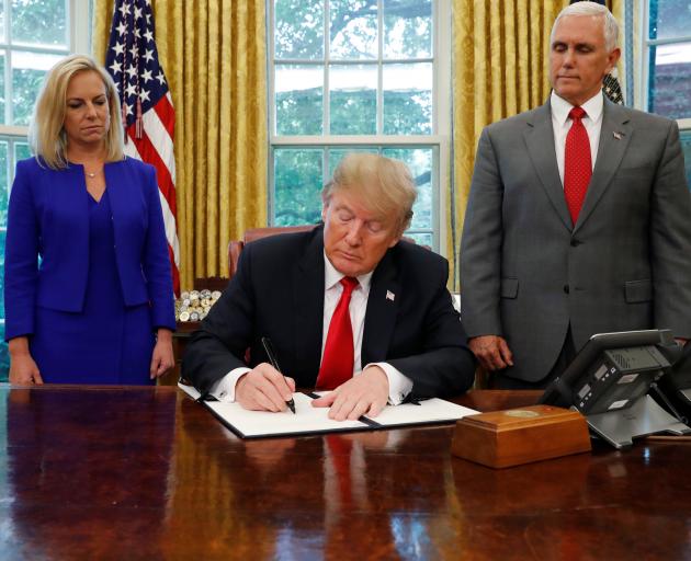 Donald Trump signs an executive order on immigration policy with Department of Homeland Security...