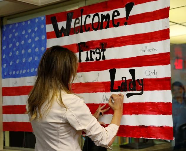Melania Trump signs a US flag made by children at the centre. Photo: Reuters 