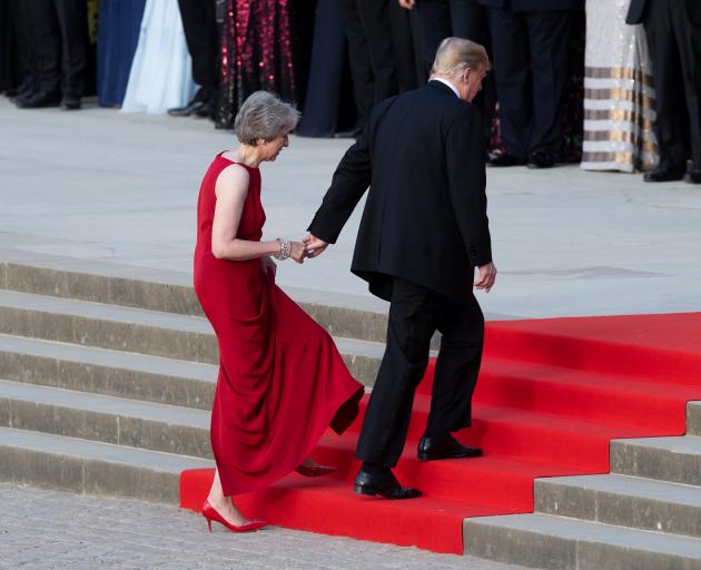 Donald Trump leads Theresa May by the hand as they climb the steps to the entrance of Blenheim...