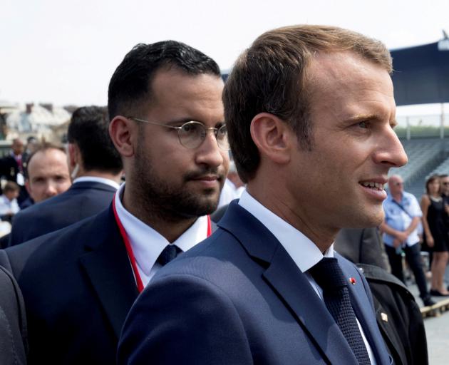 French President Emmanuel Macron walks ahead of his aide Alexandre Benalla at the Bastille Day...