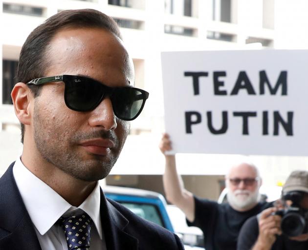 A protester holds a banner as former Trump campaign aide George Papadopoulos arrives for his...