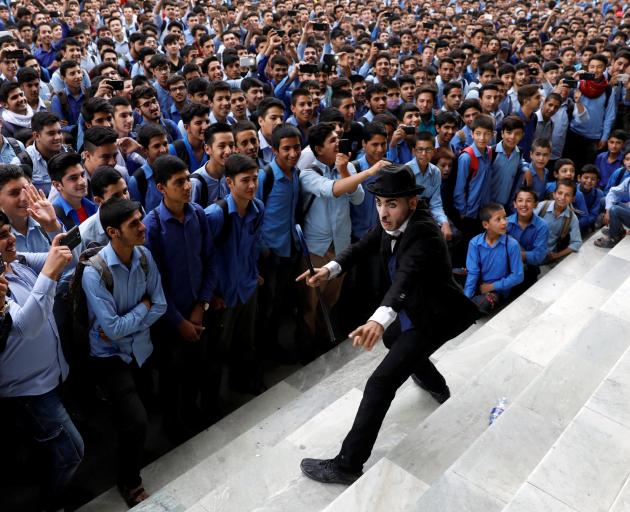 Karim Asir performing as Charlie Chaplin at a school in Kabul. Photo: Reuters 