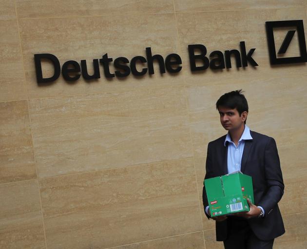 A worker leaves Deutsche Bank's London office. Hundreds of jobs were set to go there. Photo:...