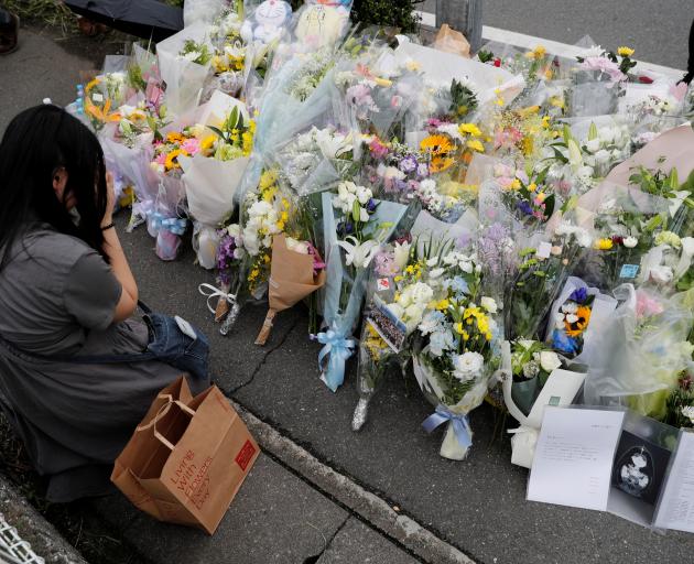 A woman prays in front flowers left for the victims. Photo: Reuters 