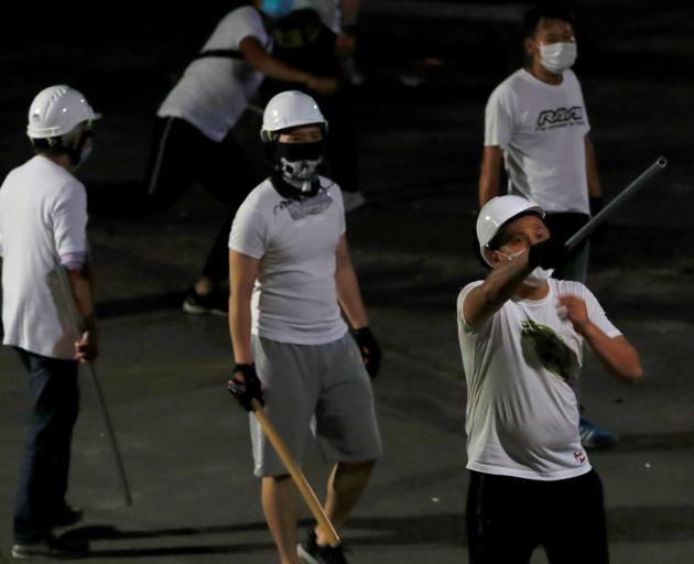 Men in white T-shirts, some armed with clubs, flooded into the rural Yuen Long station and...