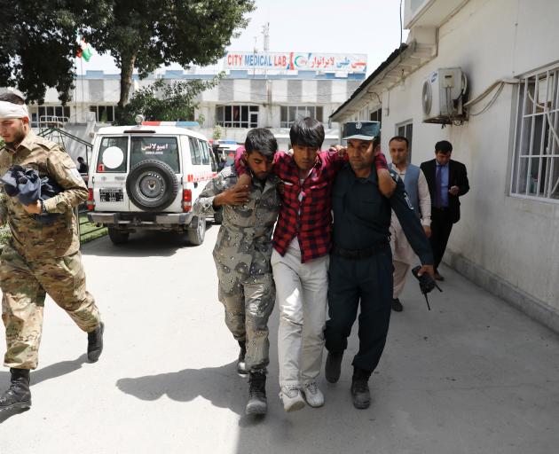 An injured man is helped to hospital after the blast in Kabul. Photo: Reuters 