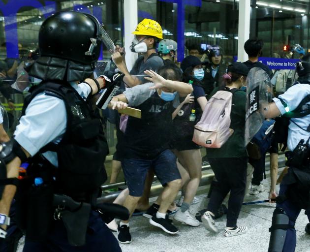 A police officer sprays pepper spray at anti-government protesters. Photo: Reuters 