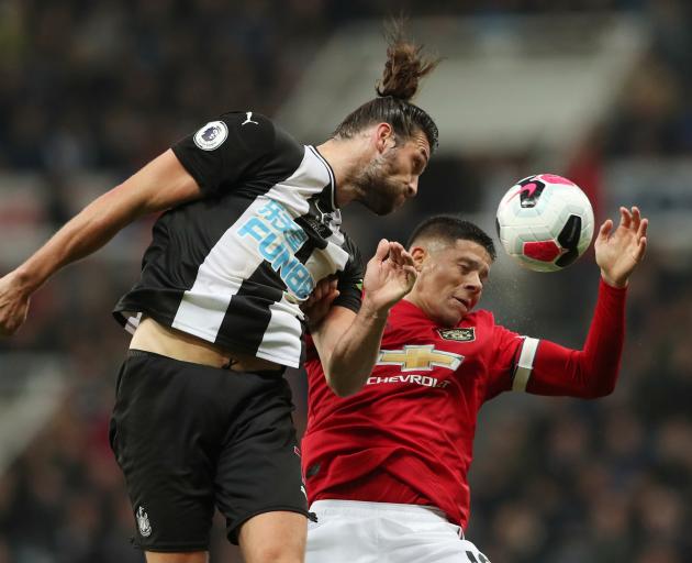 Newcastle United's Andrew Carroll (left) and Manchester United's Marcos Rojo compete for the ball...