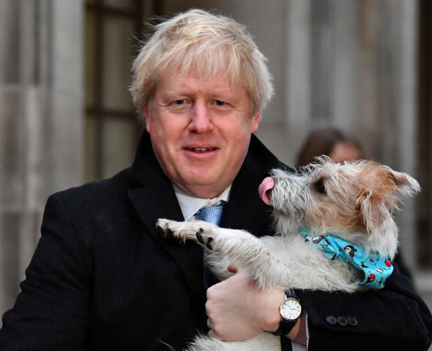 Prime Minister Boris Johnson holds his dog Dilyn after voting on Thursday. Photo: Reuters 