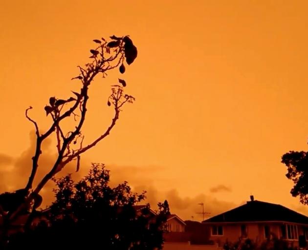 An orange sky in Auckland on Sunday. Photo: TWITTER @ZIMENAJ/via Reuters