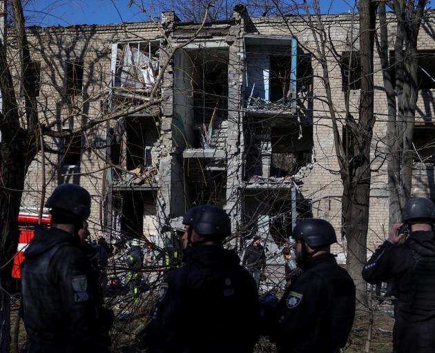 Rescuers work at a site of a residential building damaged by a Russian missile strike in the...
