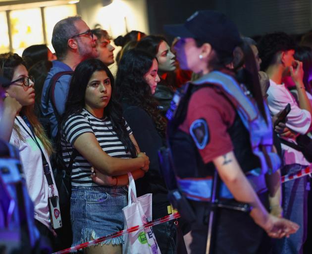 A police officer stands watch as people gather outside the hotel where Liam Payne, former One...