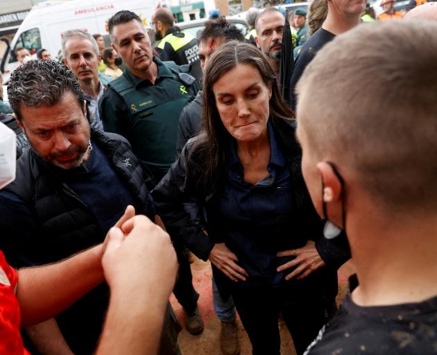 Queen Letizia listens to people during the protest. Photo: Reuters