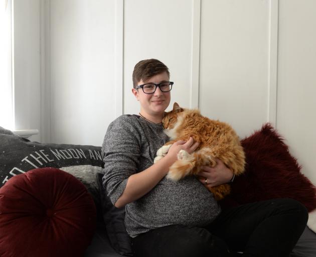 Transgender student Scout Barbour-Evans with Flash the Norwegian Forest cat at their Northeast...