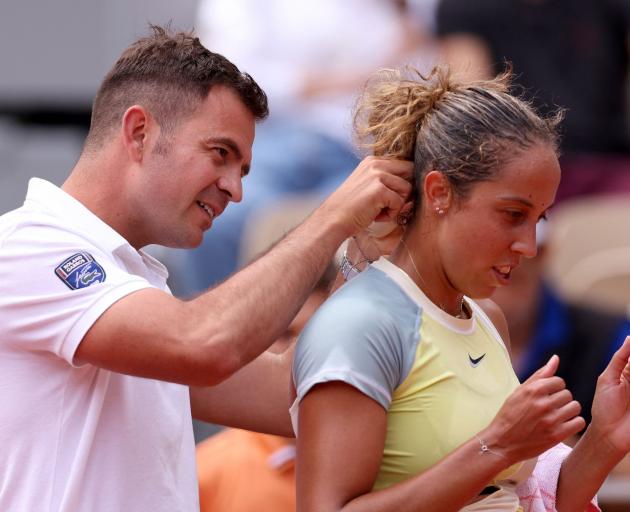 American Madison Keys has help from the umpire to untangle her necklace from her hair during her...