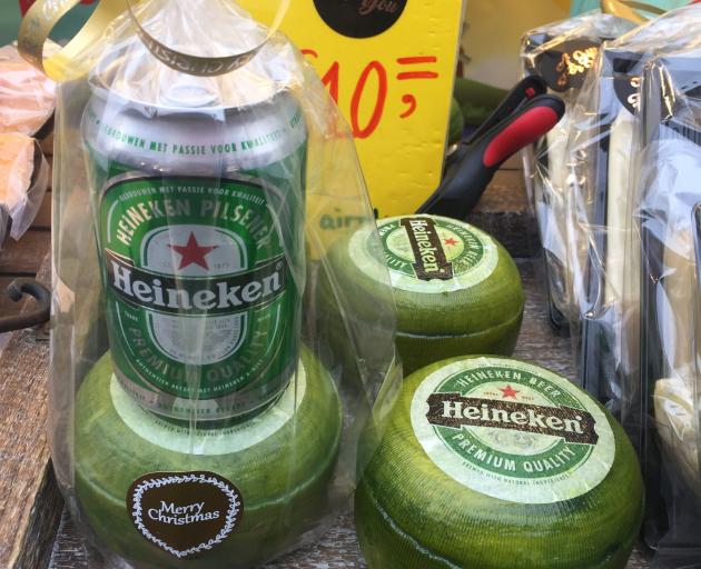 Gouda is coated in green wax and sold with a Heineken at a market in Amsterdam.  