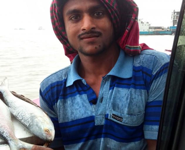 A fish seller plies his trade on the Padma RIver Ferry. 