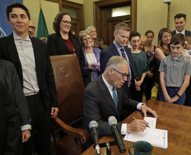 Washington Governor Jay Inslee signs the bill into law on Tuesday. Photo: AP