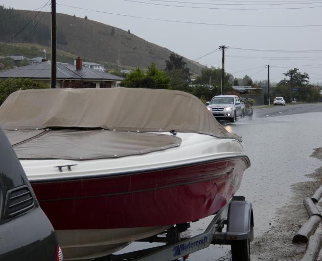 . A boat and trailer parked in Hazlett St, Clyde, is almost surrounded by surface flooding. PHOTO...