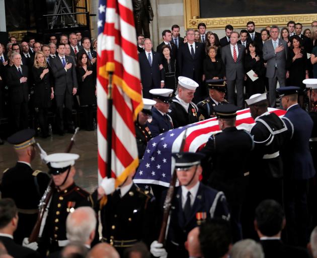 A military honour guard carries the casket of George H.W. Bush inside the Capitol rotunda in...