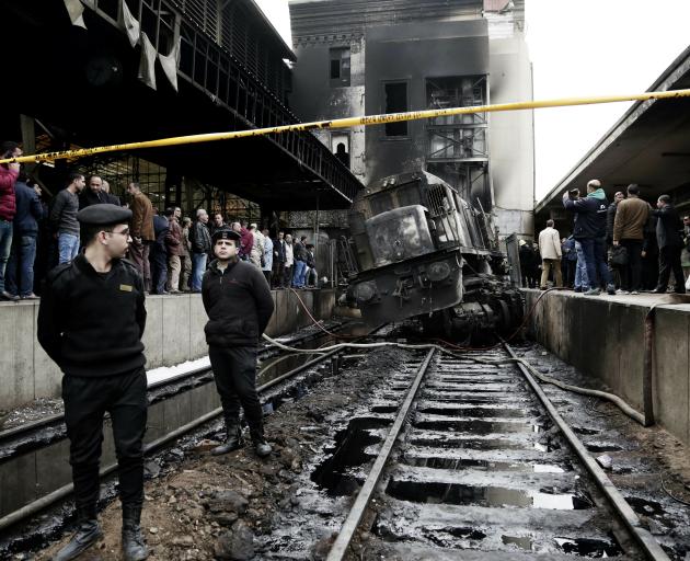Police guard the damaged train at Ramsis station after it crashed into a barrier before exploding...