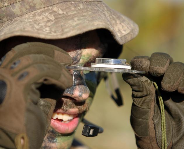 A soldier from Dunedin checks his position via compass during the section fire command orders...