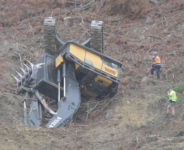 A digger clearing forestry slash above SH1 south of Waihola rolled on the sloping hillside. Photo...