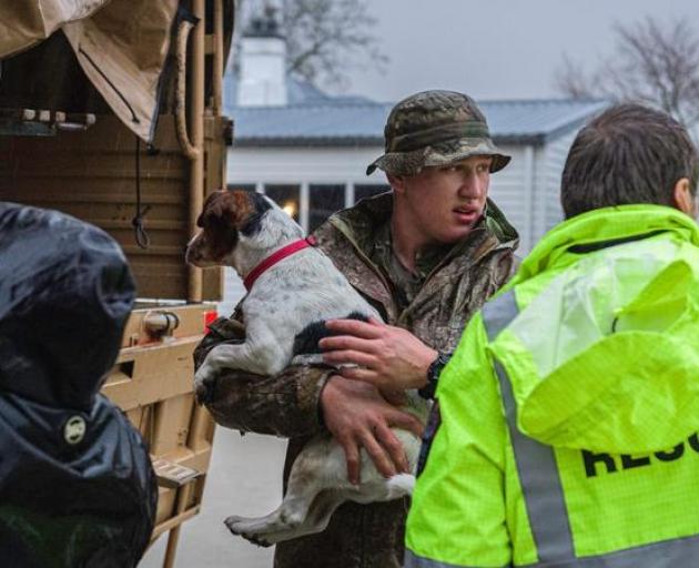 Max is helped onto a New Zealand Defence Force vehicle by Private Joshua Ley as the Stewart...