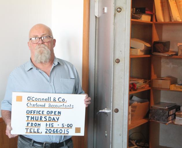 Rob ‘‘Caveman’’ McKenzie standing next to the now open safe of O’Connell and Co, which was left...