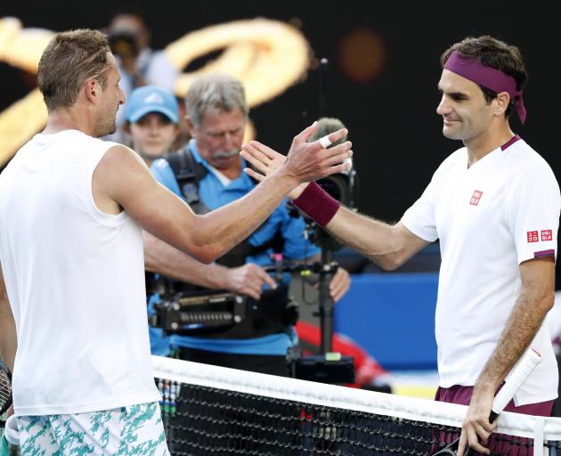 Roger Federer (right) shakes hands with Tennys Sandgren after their thrilling match. Photo: Reuters 