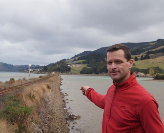 Spokes Dunedin chairman Dr Robert Thompson points at the causeway  leading away from  Roseneath, where  he suggests  a boardwalk for the cycle/walkway on the inlet side of the railway line may be cheaper than reclamation. Photo by Greta Yeoman