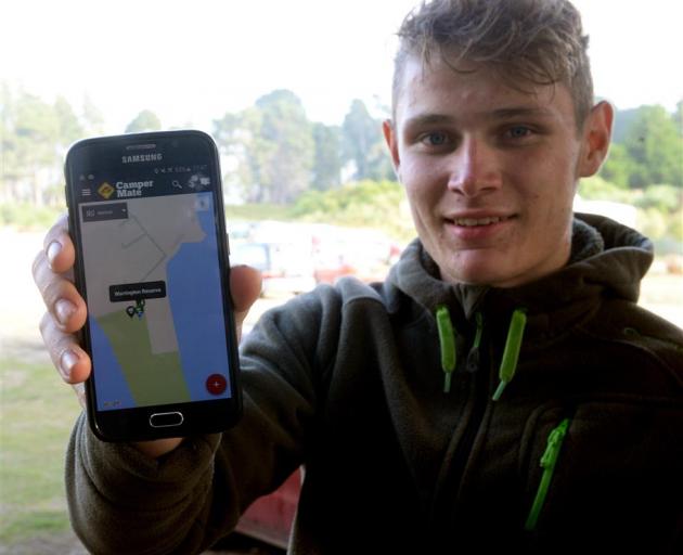 German tourist Hannes Meeh (18) displays the Camper Mate app on his smart phone at the Warrington Reserve. Photo by ODT.