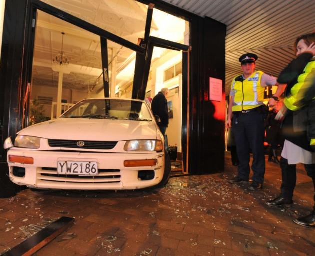 Gallery De Novo owner Richelle Byers looks at the car that crashed through the door of her art gallery last night. Photo by Gregor Richardson. 