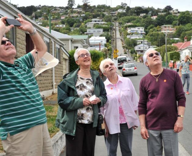 Celebrity Solstice passengers (from left) William  and Marguerite Moody, Lucille and Jackie Fraser, all of Florida,  photograph signs in Baldwin St on Saturday. Photo by Linda Robertson.