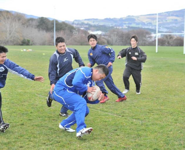 Masaya Watanabe (16) carries the ball forward as (from left) Daichi Shimamura (16), Hinata Takei (17), Shoi Yokozuka (16) and Ryota Kozuki (16) give chase during a training session at the Montecillo Ground in Dunedin yesterday. Photo by Linda Robertson
