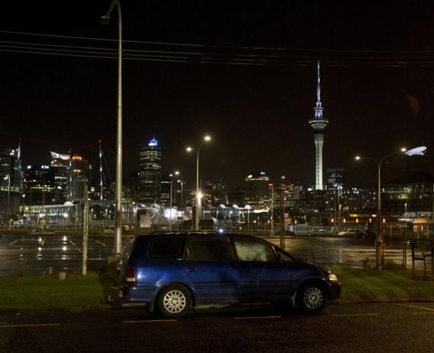 Close to home . . . A rough sleeper in a car settles down for the night on Hamer St in Auckland. PHOTO: THE NEW ZEALAND HERALD