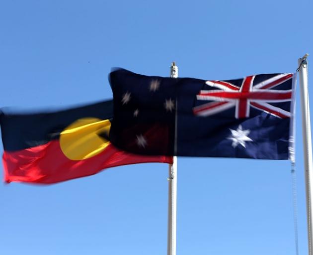 The Aboriginal (left) and  Australian flags flying on Australia Day. Photo: Getty Images 