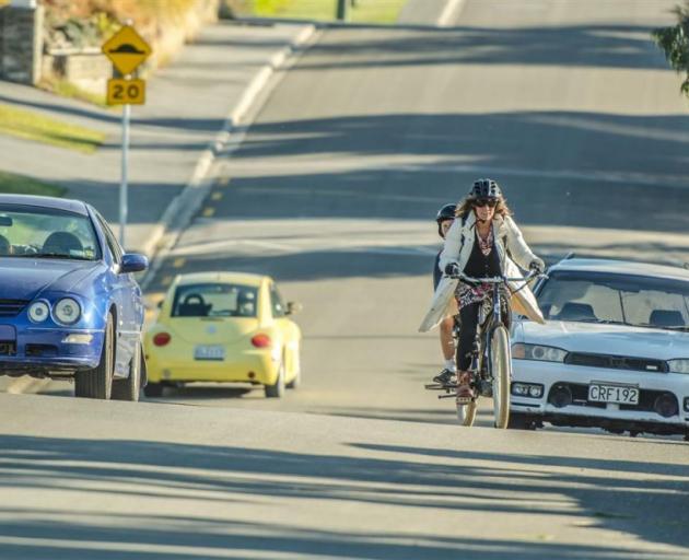 Gina Dempster takes on a steep hill up to Wanaka Primary School on her electric cargo bike with 10-year-old son Jem Curtis. Photo: Si Williams