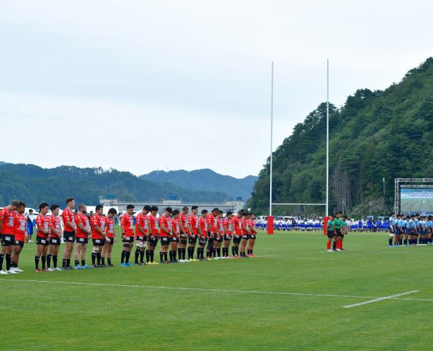 Players observe a minute of silence for the victims of the Great East Japan Earthquake and...