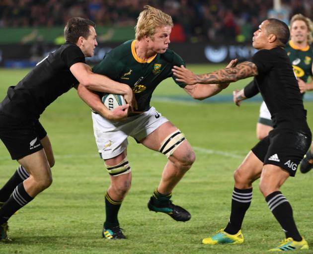 Ben Smith (left) and Aaron Smith try to stop a barnstorming Springbok Pieter-Steph du Toit in...