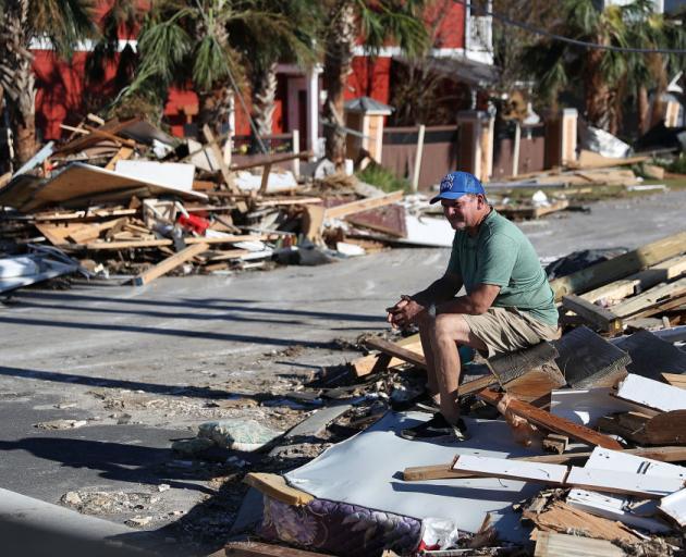 Hector Morales sits on a pile of rubble after hurricane Michael passed Mexico Beach in Florida...