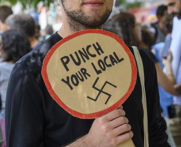 A protestor in Portugal holds a sign opposing far right groups. Photo: Getty Images