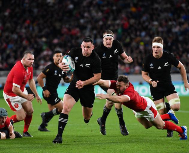 All Black Ryan Crotty evades the tackle of Wales' Owen Lane to score a try during the bronze...