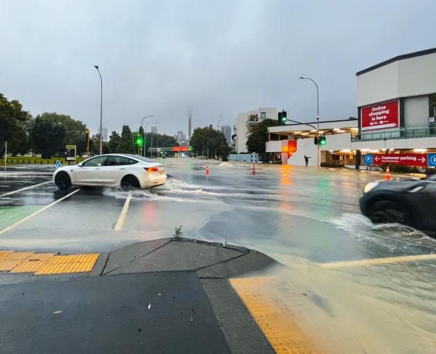 Cars drive through floodwater in Victoria St, Auckland. Photo: Getty Images