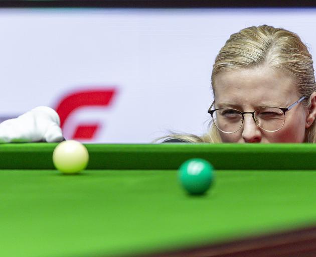 Snooker referee Maike Kesseler places the ball during a match between David Gilbert, of England,...