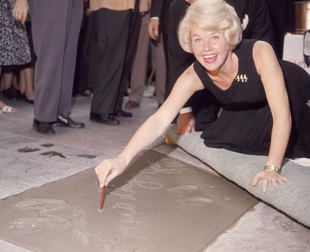 Doris Day signs her name in cement on the Hollywood Walk of Fame in 1961. Photo: Getty Images 